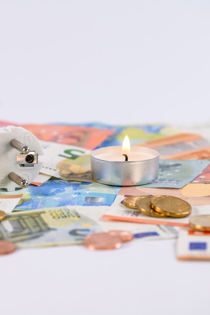 services-03 A burning candle on Euro money with a power plug symbolizing energy costs.