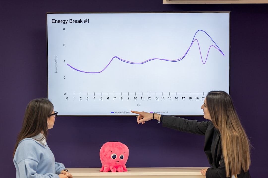 two-women-analyze-a-line-graph-on-a-screen-71pmz9rn-ha